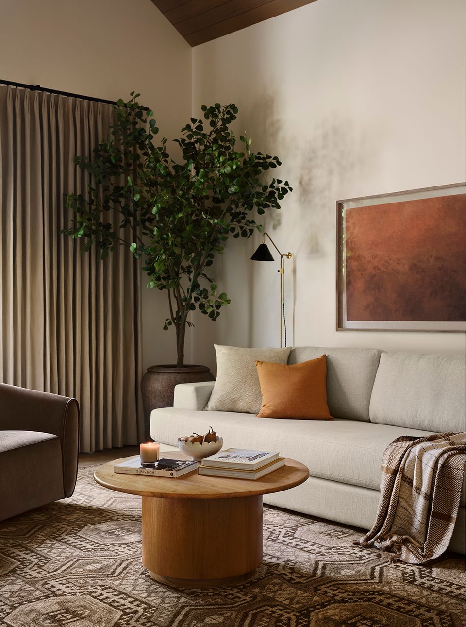Modern warm beige living room combining soft furnishings with warm wood tones, terracotta accents, lush greenery, and layered textures for an inviting, contemporary aesthetic.