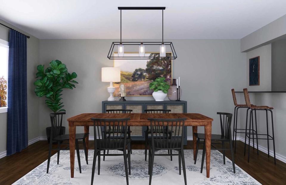 Rustic farmhouse dining room with warm wood table, black spindle chairs, industrial pendant lighting, and neutral color palette with natural greenery accents
