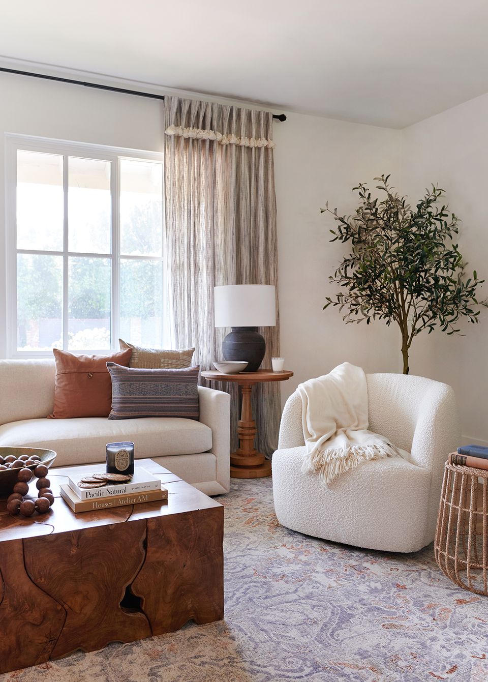 Warm contemporary living room blending cream upholstery with cognac leather and botanical accents