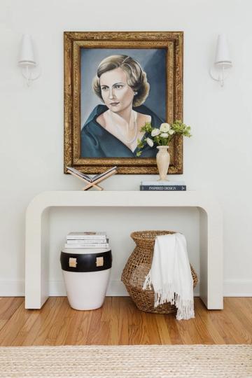 Classic entryway with ornate gold portrait frame and minimalist white console styling