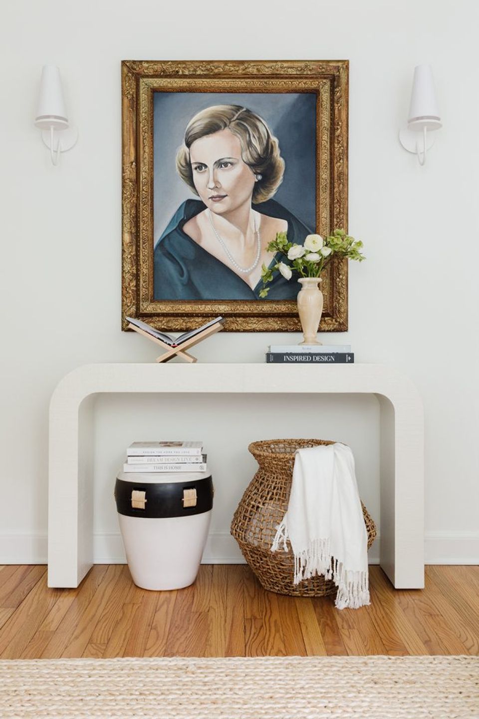Classic entryway with ornate gold portrait frame and minimalist white console styling
