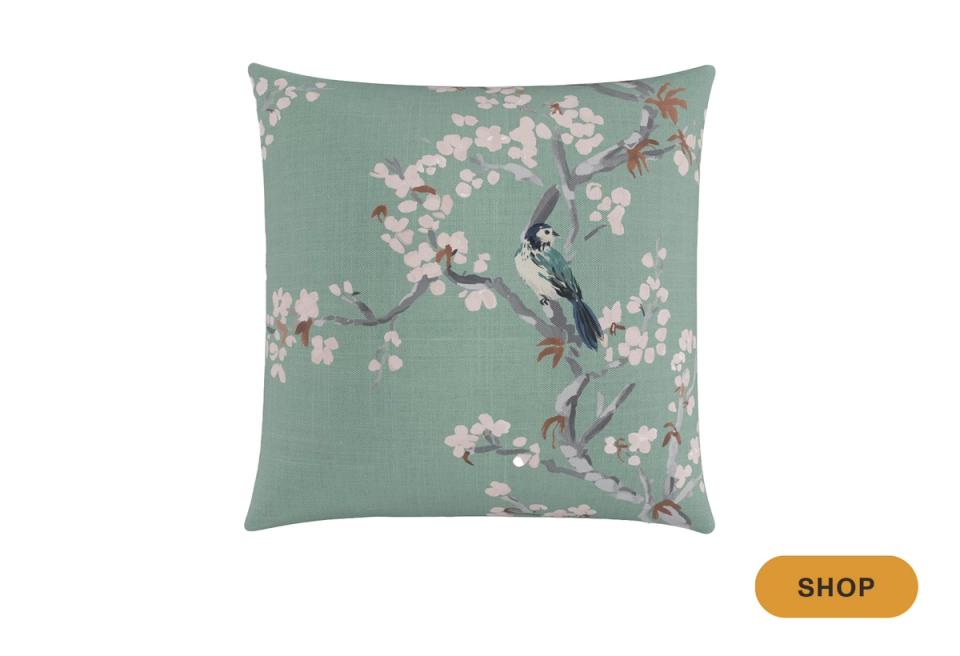 Botanical throw pillow featuring delicate white blossoms on soft sage green ground