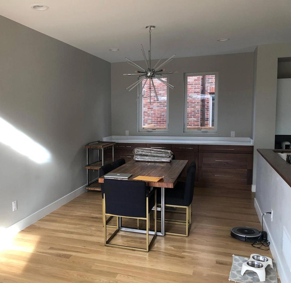 Modern industrial space with dark wood desk, geometric metal chandelier, and contemporary styling