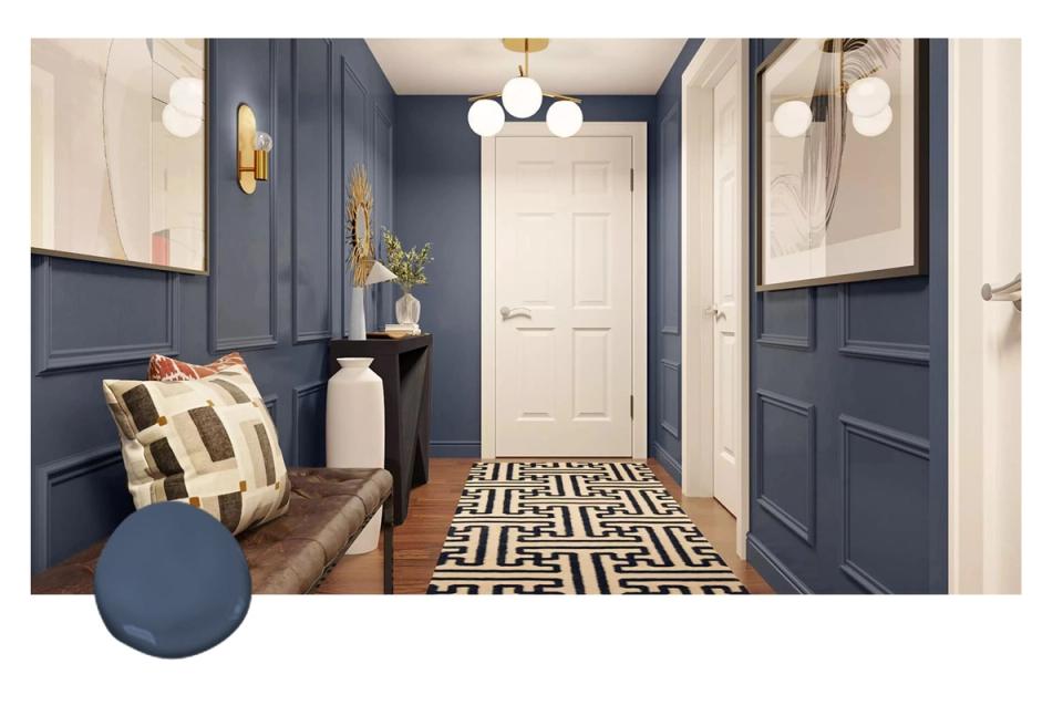 Classic entryway with navy wainscoting, brass fixtures, geometric black-and-white runner, and cream doors creating a sophisticated traditional aesthetic