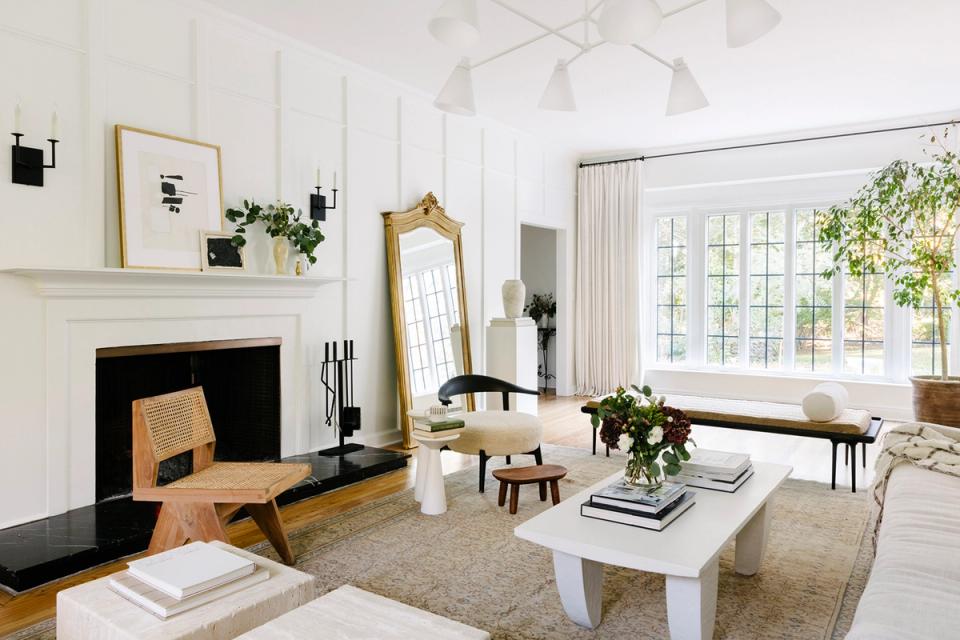 Bright minimalist living room with fireplace, natural wood accents, and abundant greenery