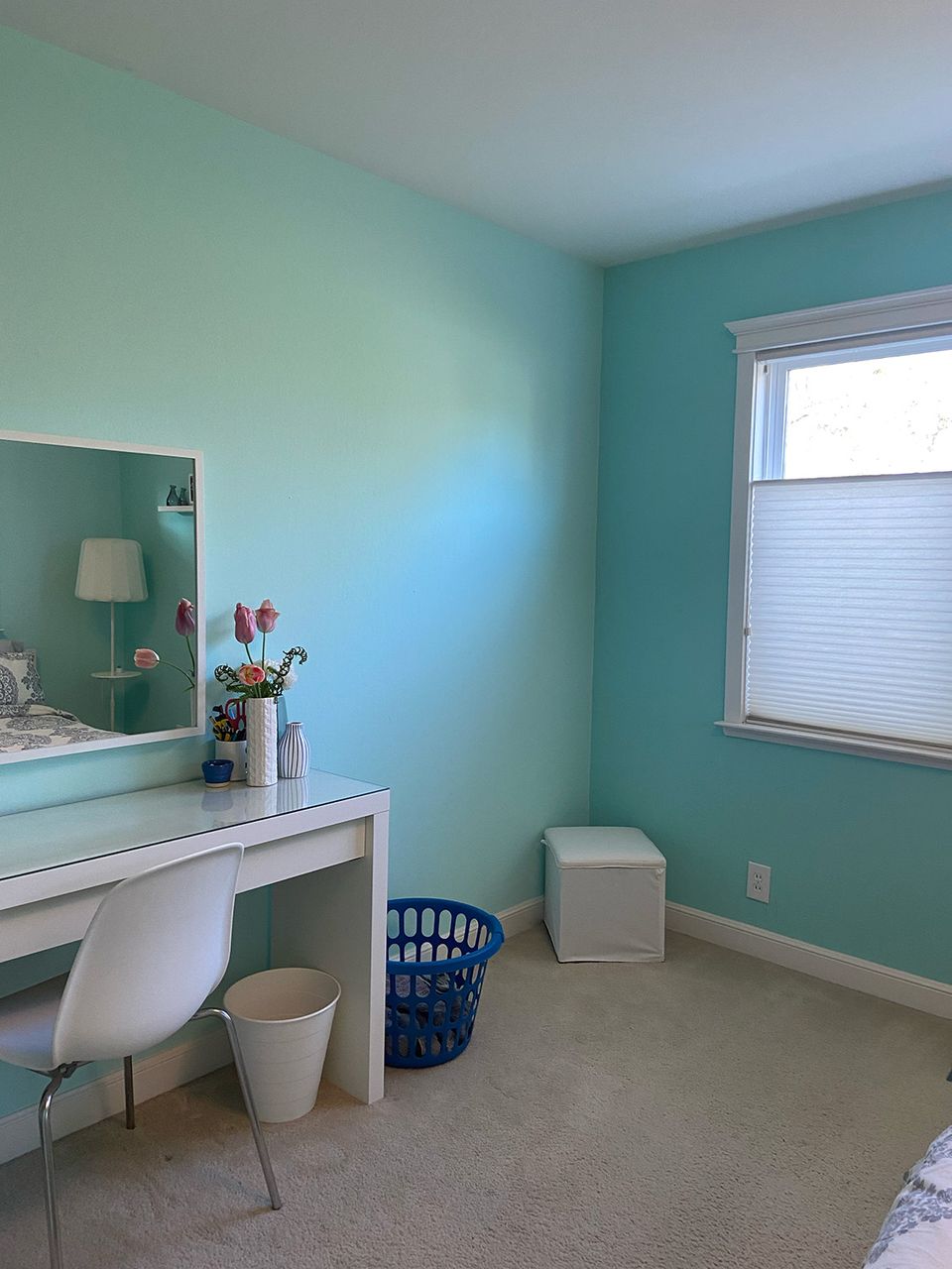 Dated turquoise vanity area with bare walls, simple desk setup, and institutional 2000s color scheme