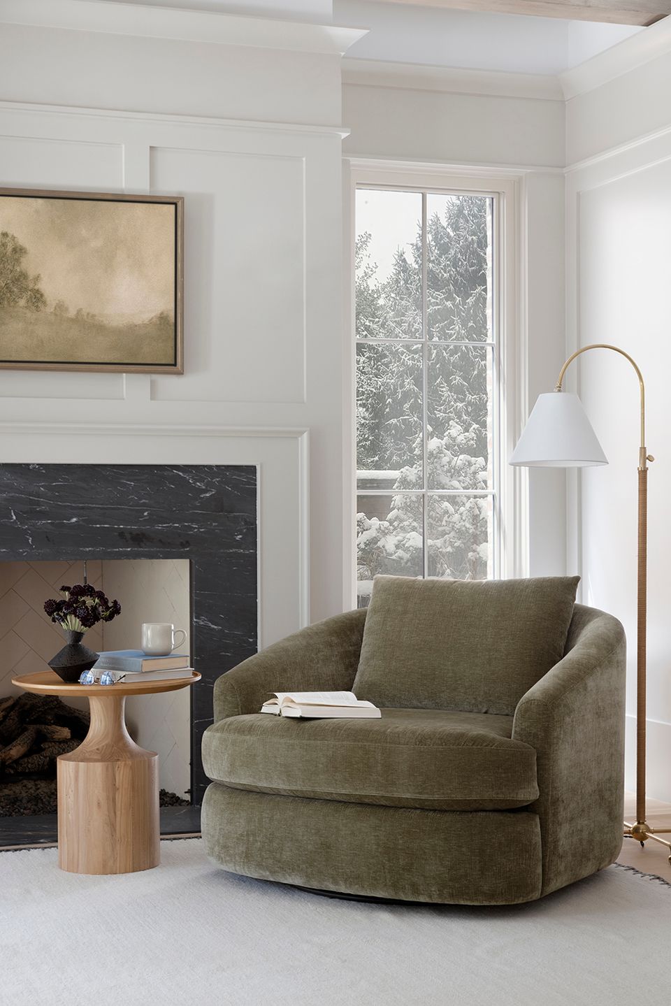 Modern classic living room with sage green rounded chair, fireplace surround, and soft taupe color scheme.