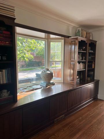 Serene kitchen workspace with dark wood built-ins, open shelving, and abundant natural light from windows