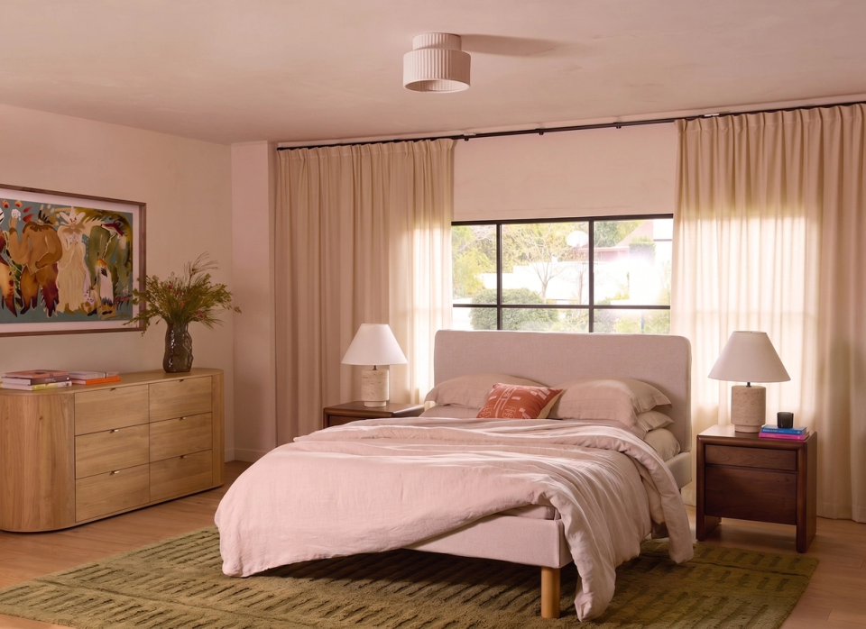 Bedroom with a wood dresser, upholstered bed, and green striped bedding
