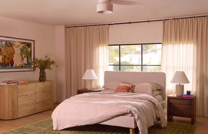Bedroom with a wood dresser, upholstered bed, and green striped