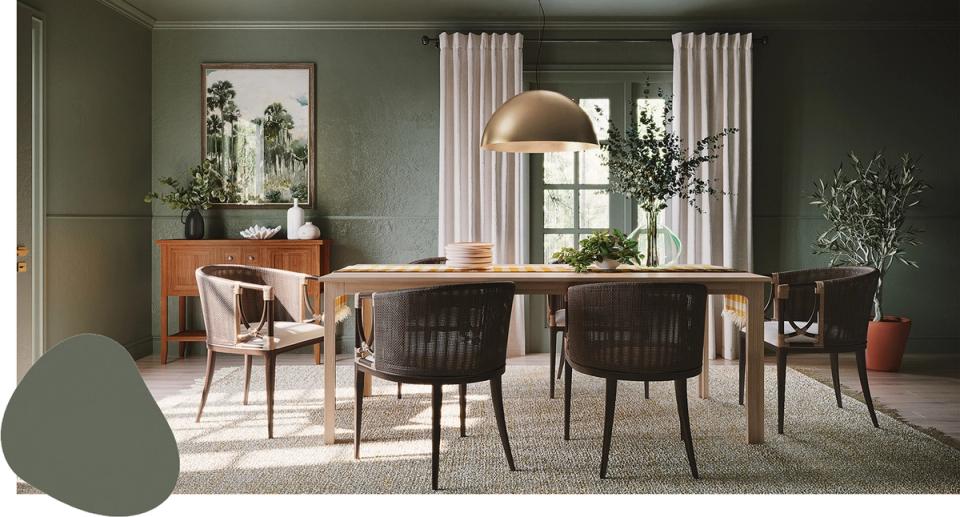 Scandinavian dining room with soft sage green walls, natural wood table, and minimalist decor for calm organic elegance