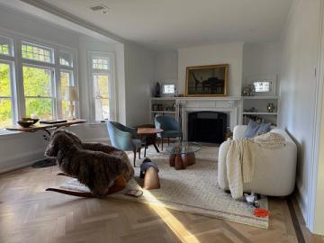 Transitional living room with light wood floors, fireplace, blue accent chair, and contemporary furnishings in neutral palette
