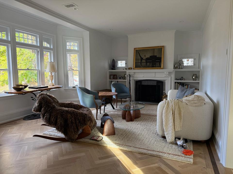 Transitional living room with light wood floors, fireplace, blue accent chair, and contemporary furnishings in neutral palette