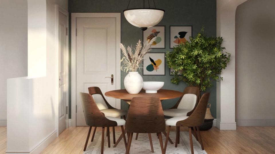 Contemporary dining space with dark green accent wall, warm wood table, and botanical greenery.