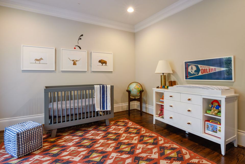 Complete Southwestern nursery with geometric rug, gray crib, white dresser, and vintage globe accent