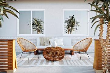 Tropical-inspired patio with woven rattan chairs, palm plants, and coastal charm