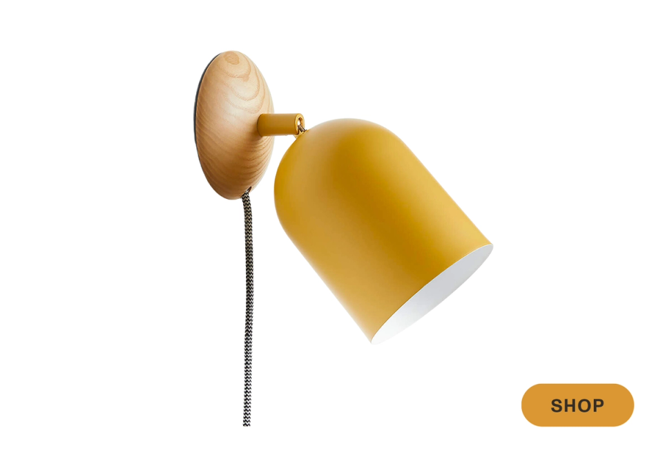 Modern mustard yellow plug-in sconce with sculptural wooden backplate and minimalist design