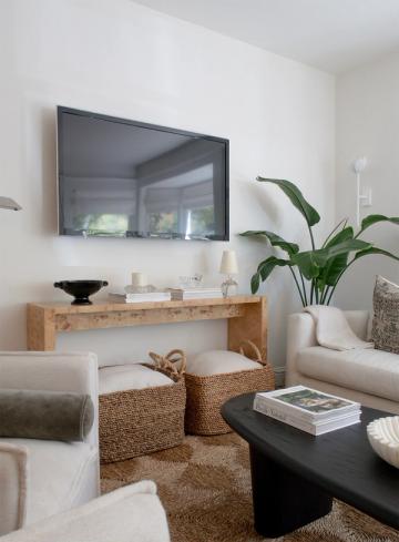Coastal modern living room with natural wood console, woven baskets, and soft neutrals
