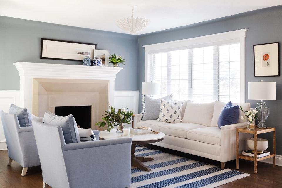 Sophisticated living room with soft blue walls, cream sofa, and classic fireplace focal point