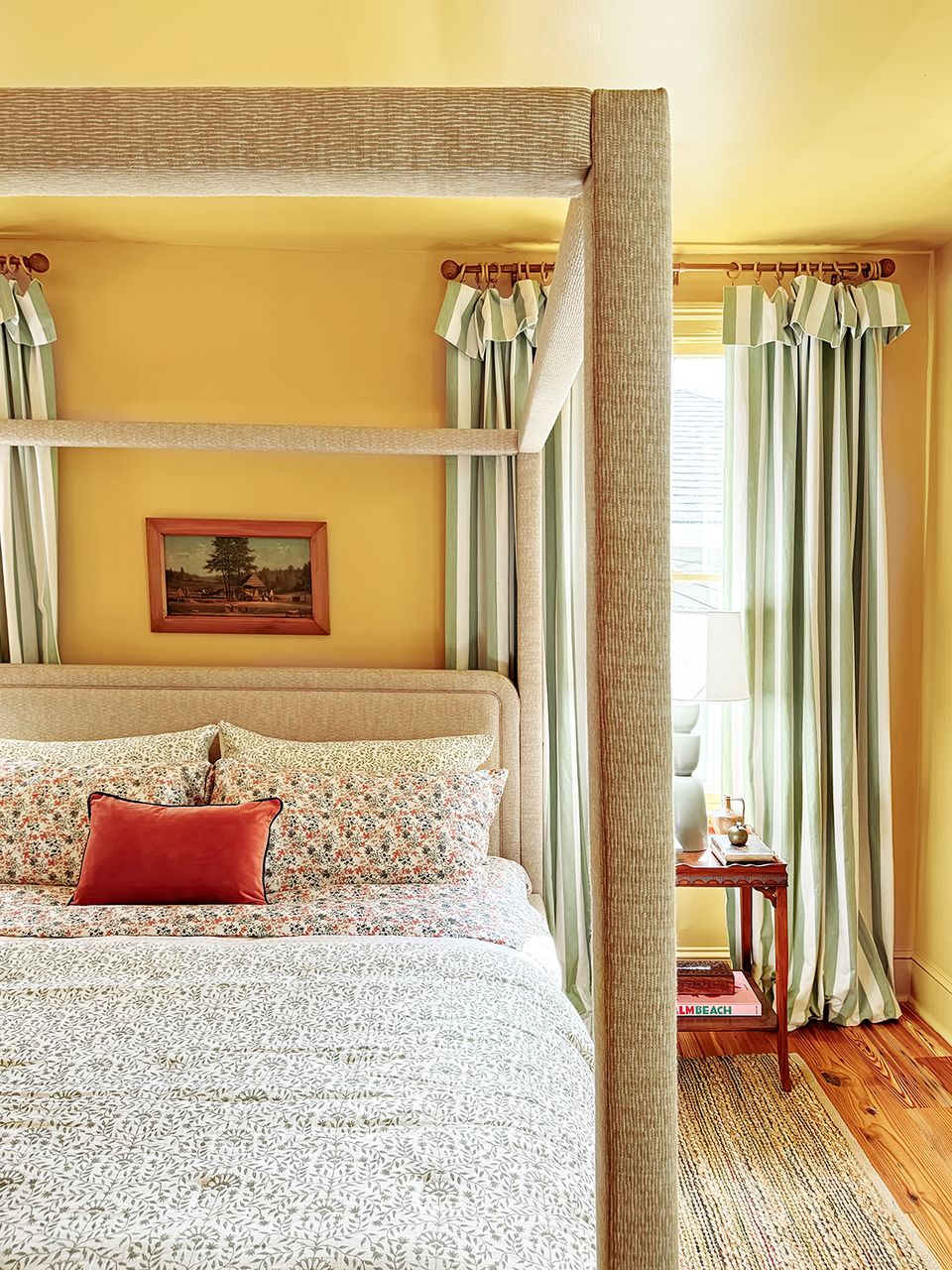 Warm golden yellow canopy bedroom with cream textiles and natural light