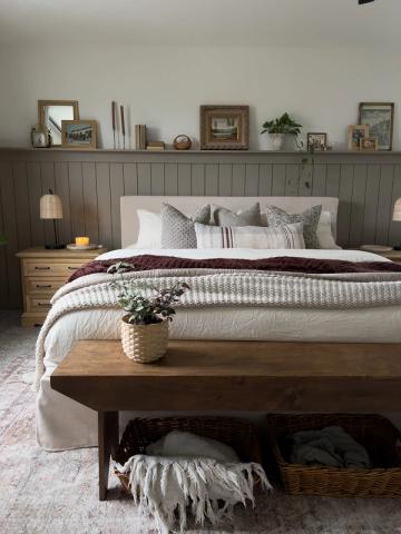 Farmhouse bedroom with sage green shiplap accent wall, neutral bedding, and rustic wood bench