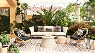 Tropical patio with cream sofa, woven chairs, geometric rugs, lush plants, and warm neutral tones creating a relaxed outdoor retreat.