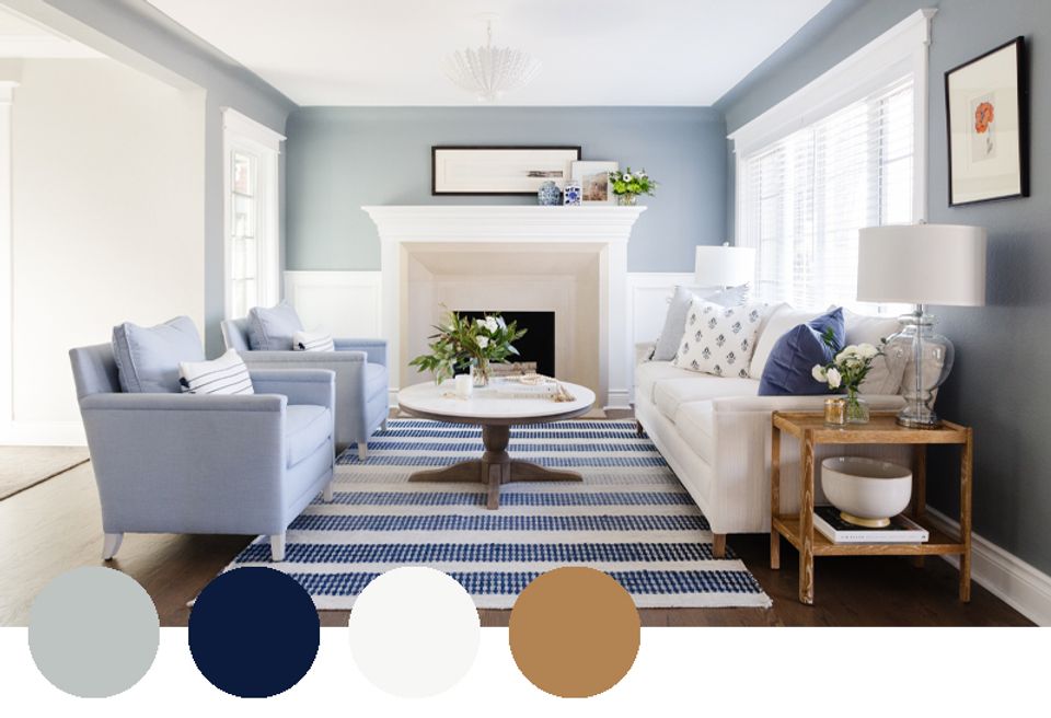 Serene coastal-inspired living room in soft blue, navy, and warm wood tones with striped accents and fireplace focal point