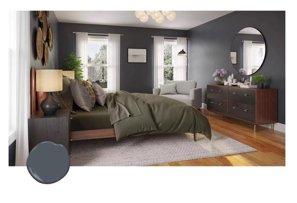 Serene bedroom with charcoal navy walls, sage green bedding, natural wood dresser, and soft warm lighting creating a calming retreat