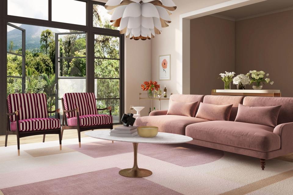 Modern living room blending mauve sofa with burgundy striped chairs, sculptural lighting, and garden views