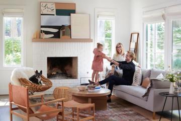 Warm, eclectic living room with mid-century furniture, terracotta accents, and layered textures in natural wood and woven pieces