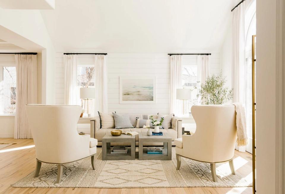 Serene, light-filled sitting area with soft cream tones, upholstered chairs, and abundant natural window light