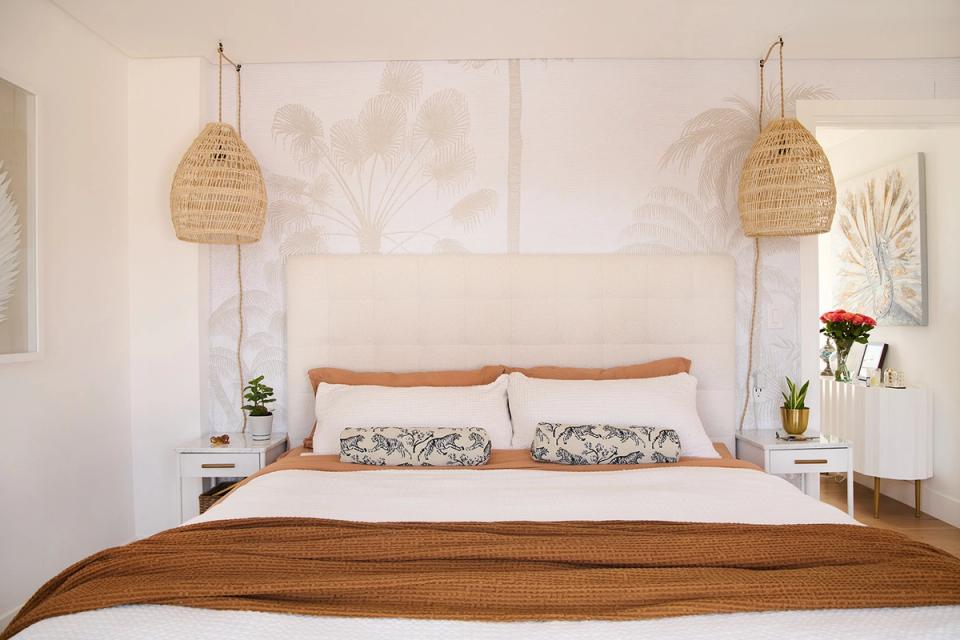 Coastal-inspired bedroom with natural wood accents, rattan pendants, and soft neutral tones