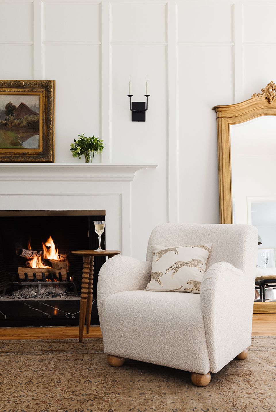 Modern fireplace lounge with cream upholstery, historic mirrors, and minimalist wall paneling
