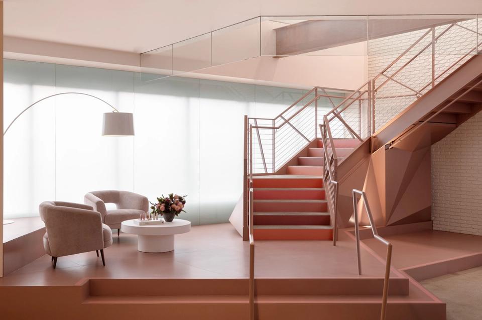 Multi-level modern space with terracotta stairs, minimalist seating, and natural light