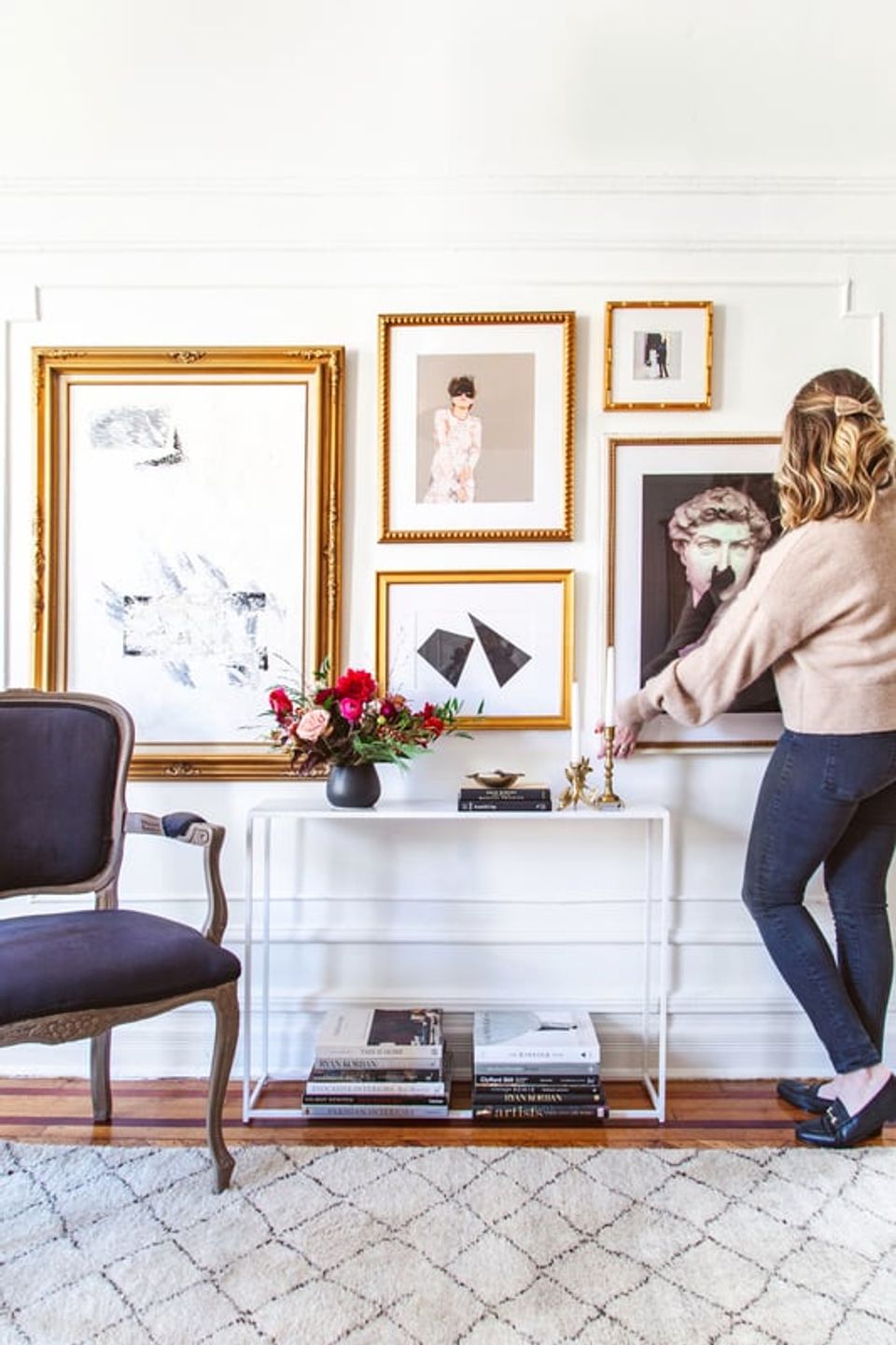 Eclectic gallery wall with mixed gold frames on white shiplap, blending vintage and modern art pieces in neutral tones