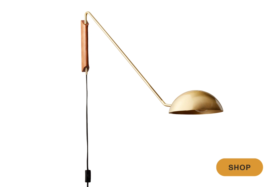 Mid-century brass arc sconce with wood accent and warm metallic finish