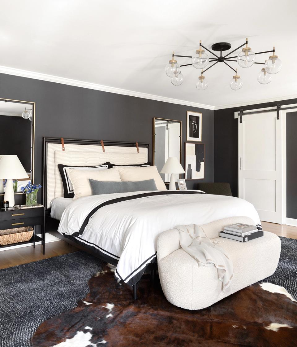 Contemporary bedroom with charcoal walls, crisp white bedding, and minimalist decor creating calm contrast