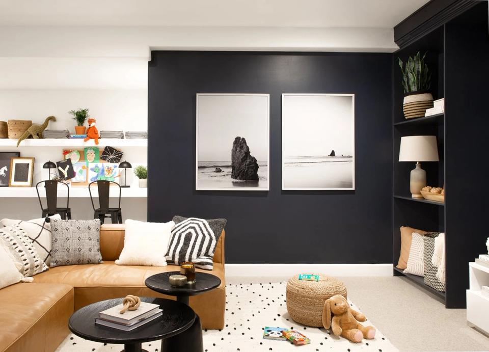 Modern living room with diptych minimalist art on deep navy wall and warm leather furniture
