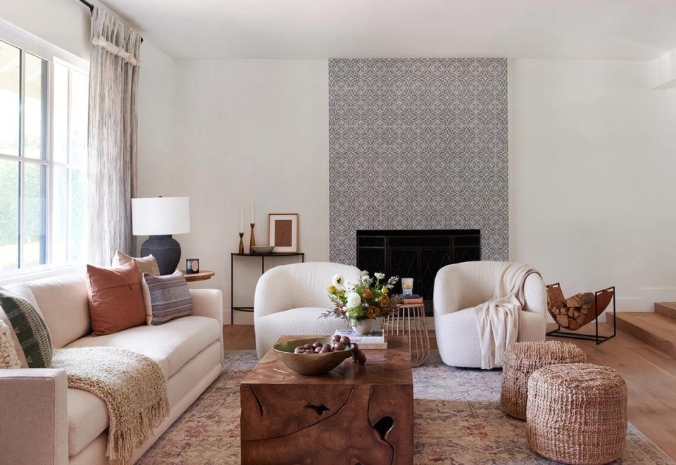 Serene living room with cream and taupe tones, featuring a fireplace wall and abundant white space for balance