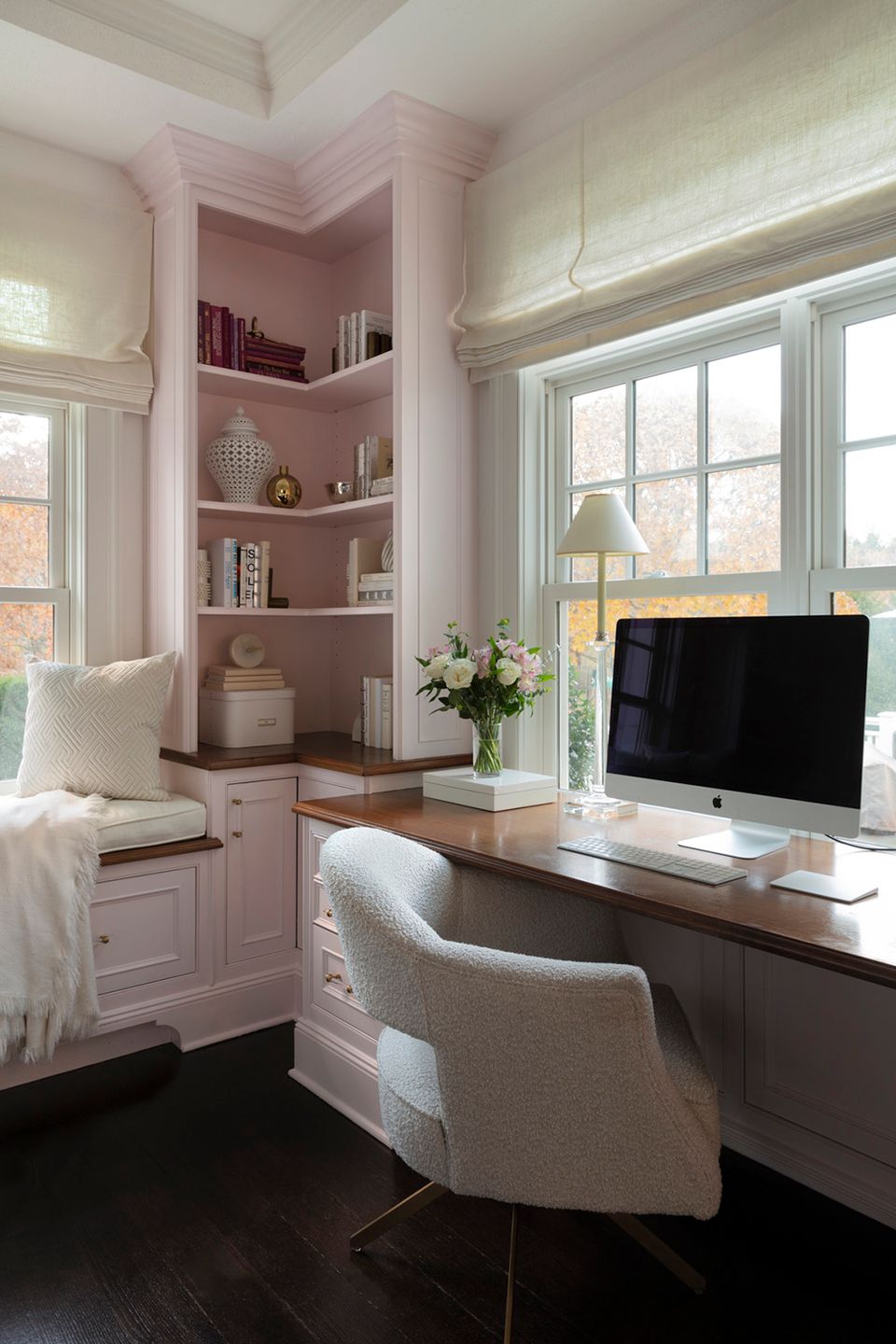 Sophisticated rose-mauve office nook with built-in corner shelving and black desktop setup