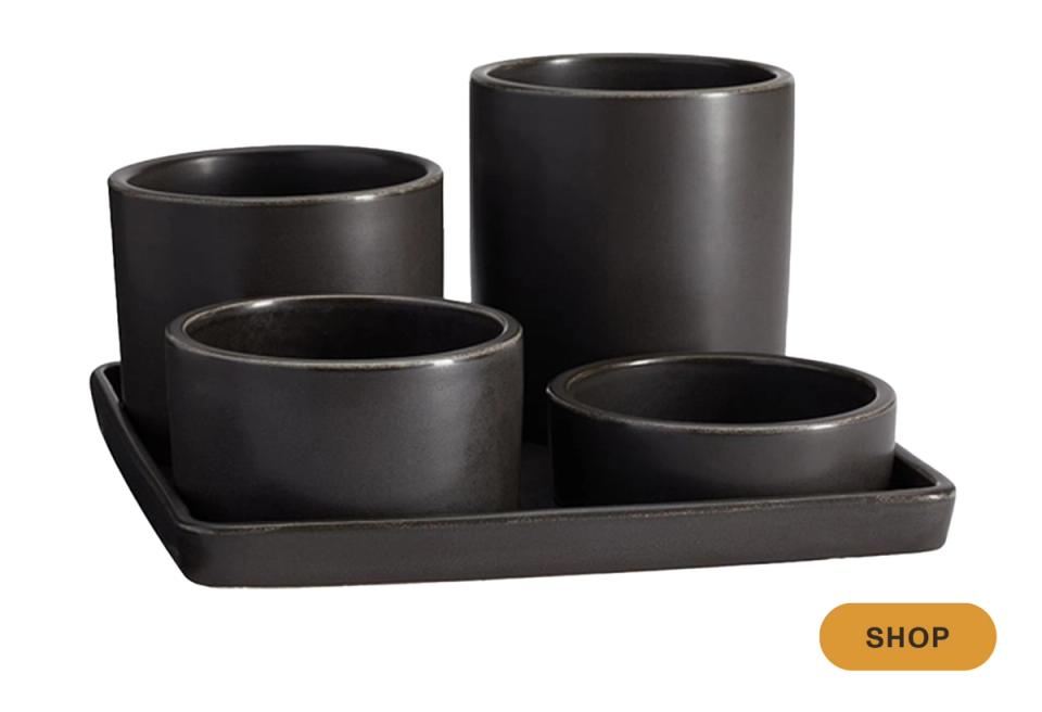 Modern black ceramic planter set on matching tray with contemporary aesthetic