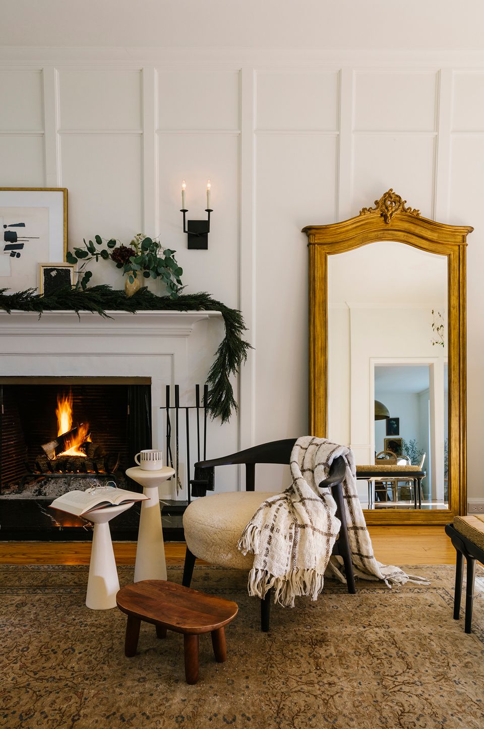 Elegant fireplace setting with gold ornate mirror, cream seating, and cozy fall textiles.