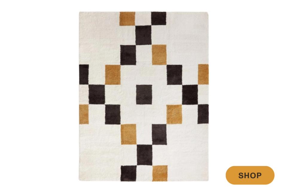 Minimalist area rug with scattered checkerboard blocks in brown, black, and cream
