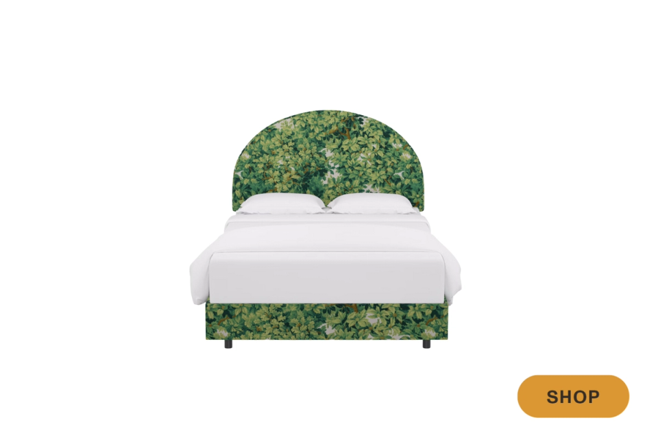 Modern botanical bed frame with emerald green patterned upholstered headboard and base, white bedding, contemporary design