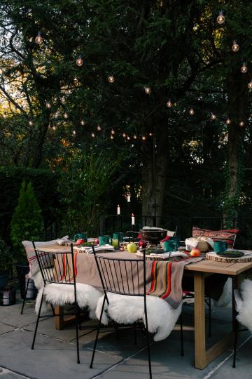 Moody boho garden dinner setting with hanging lanterns and rich jewel-tone accents