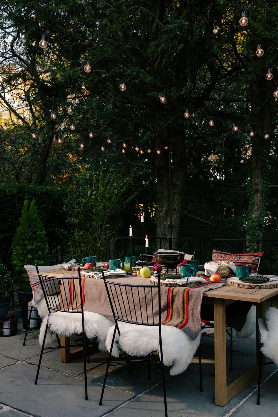 Moody boho garden dinner setting with hanging lanterns and rich jewel-tone accents