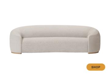 Modern curved cream sofa with minimalist design and architectural rounded arms