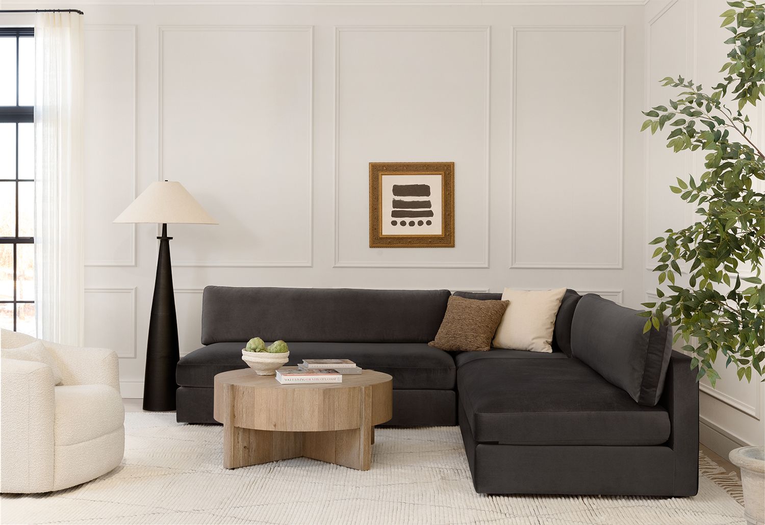 Contemporary living room with charcoal sectional, natural wood table, and neutral monochromatic palette