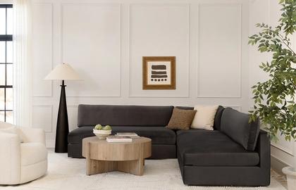 Contemporary living room with charcoal sectional, natural wood table, and neutral monochromatic palette