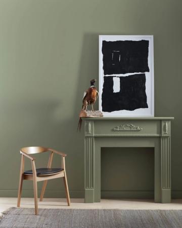 Sophisticated living space with sage green walls, modern fireplace mantel, and mid-century furniture